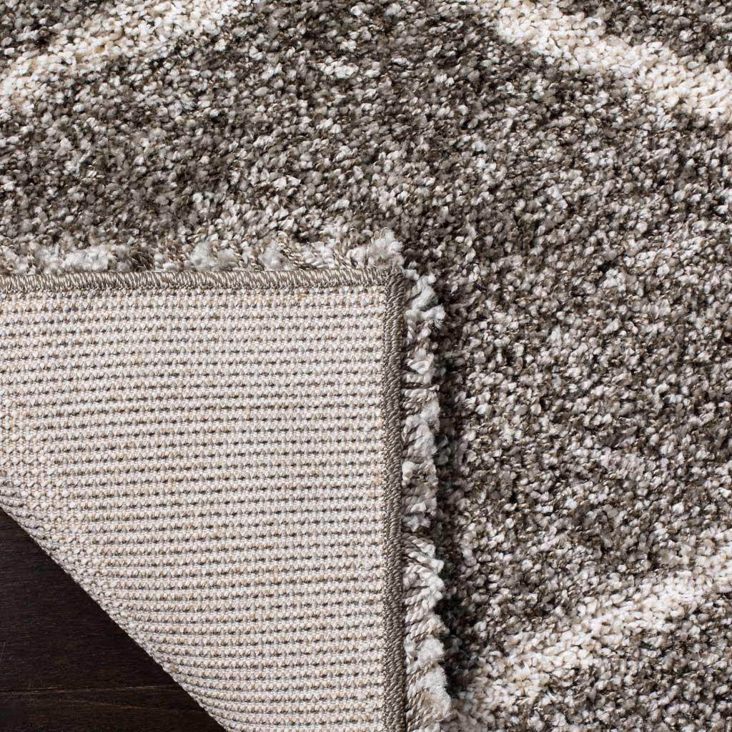 Woven underside and a bound edge support the gray shag rug