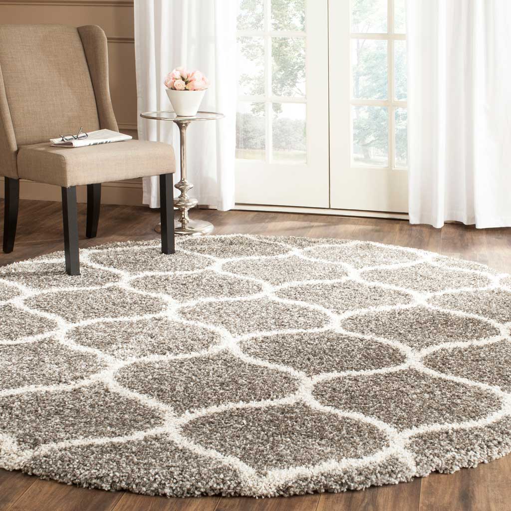 An ivory ogee trellis enlivens the speckled gray pile of this round shag rug