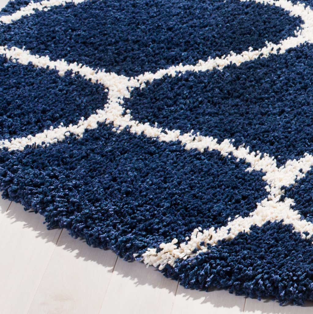 Plush navy fibers and creamy ivory curves meet along the cushioned rug edge