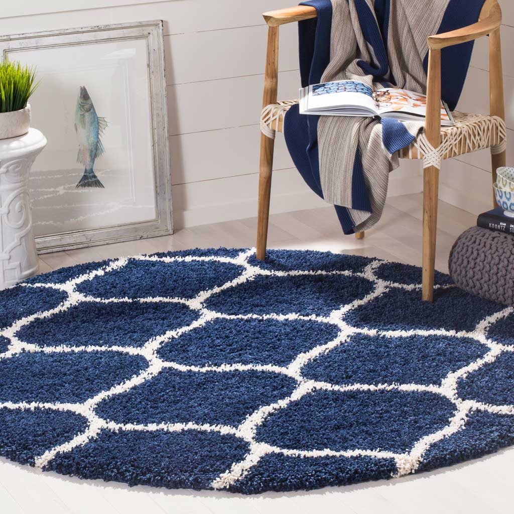 A curving ivory trellis pops against the deep navy shag of this round rug