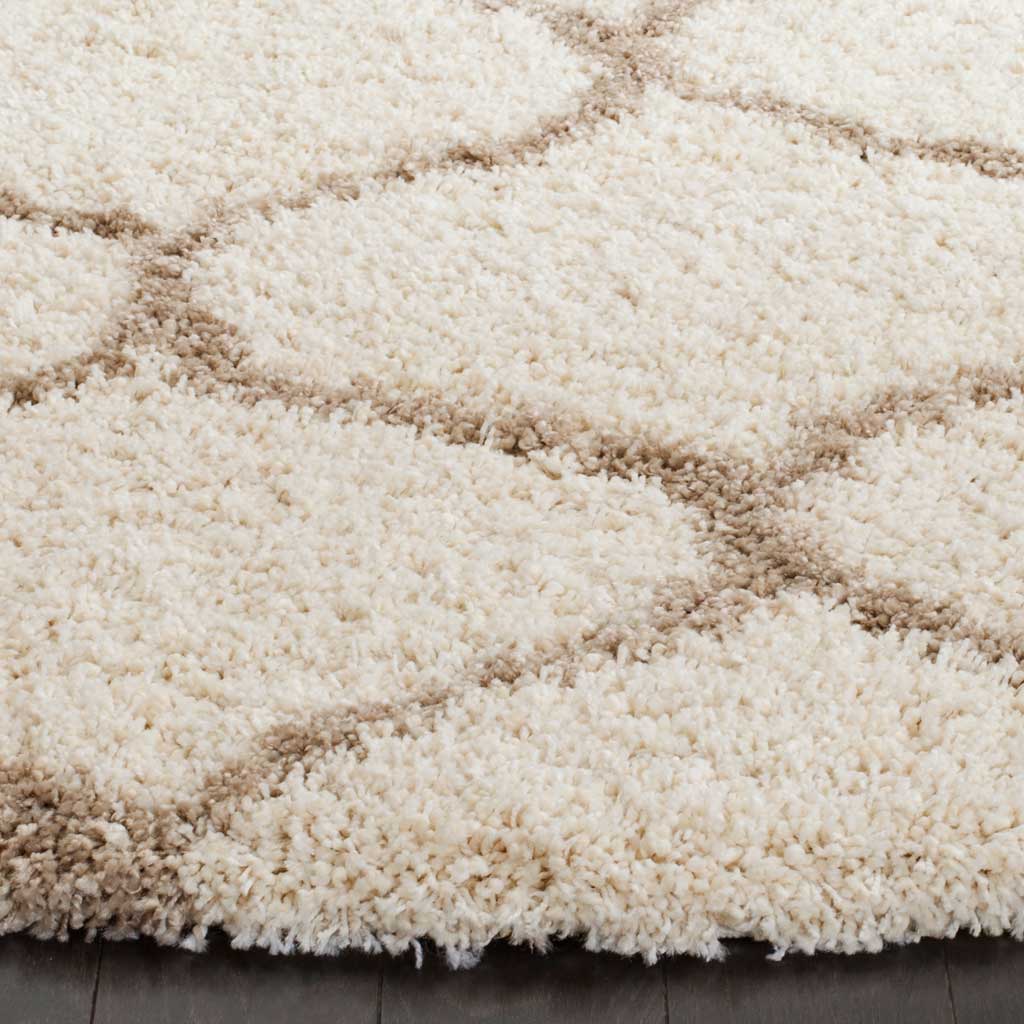 Thick ivory fibers and soft beige ogee lines create a plush, textured edge