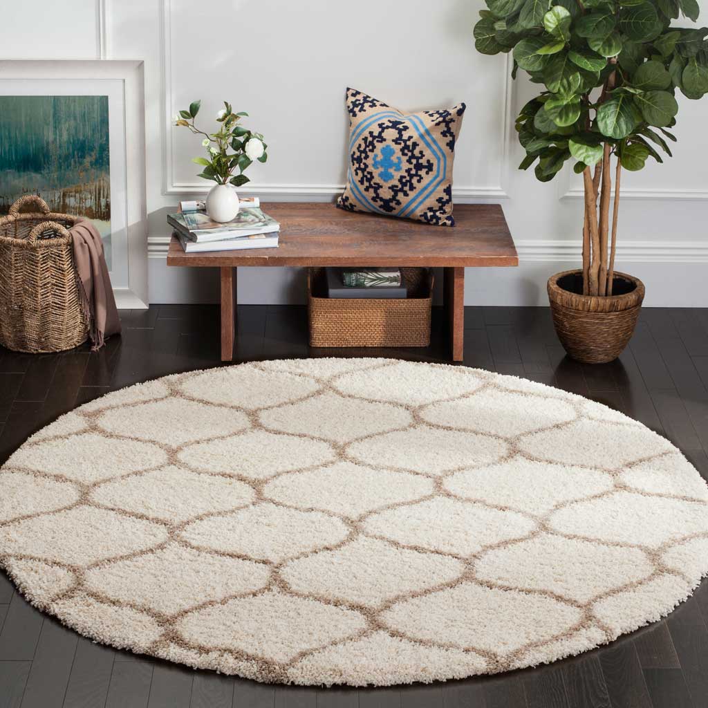 A subtle beige curving lattice warms the creamy surface of this round shag rug