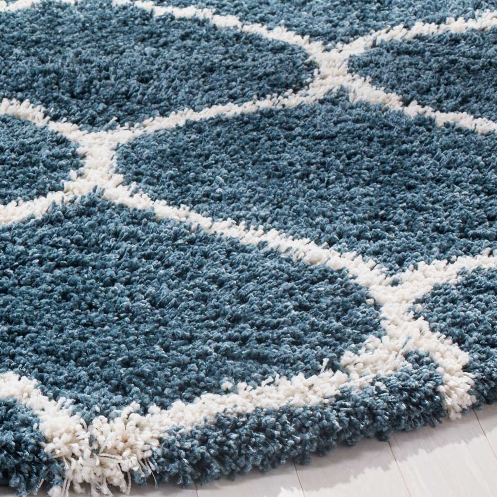 Soft slate blue shag frames an ivory curving lattice along the rug's plush edge