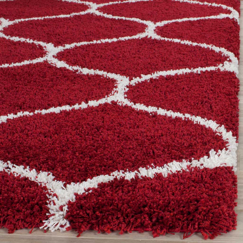 Deep red fibers meet raised ivory curves along a plush edge