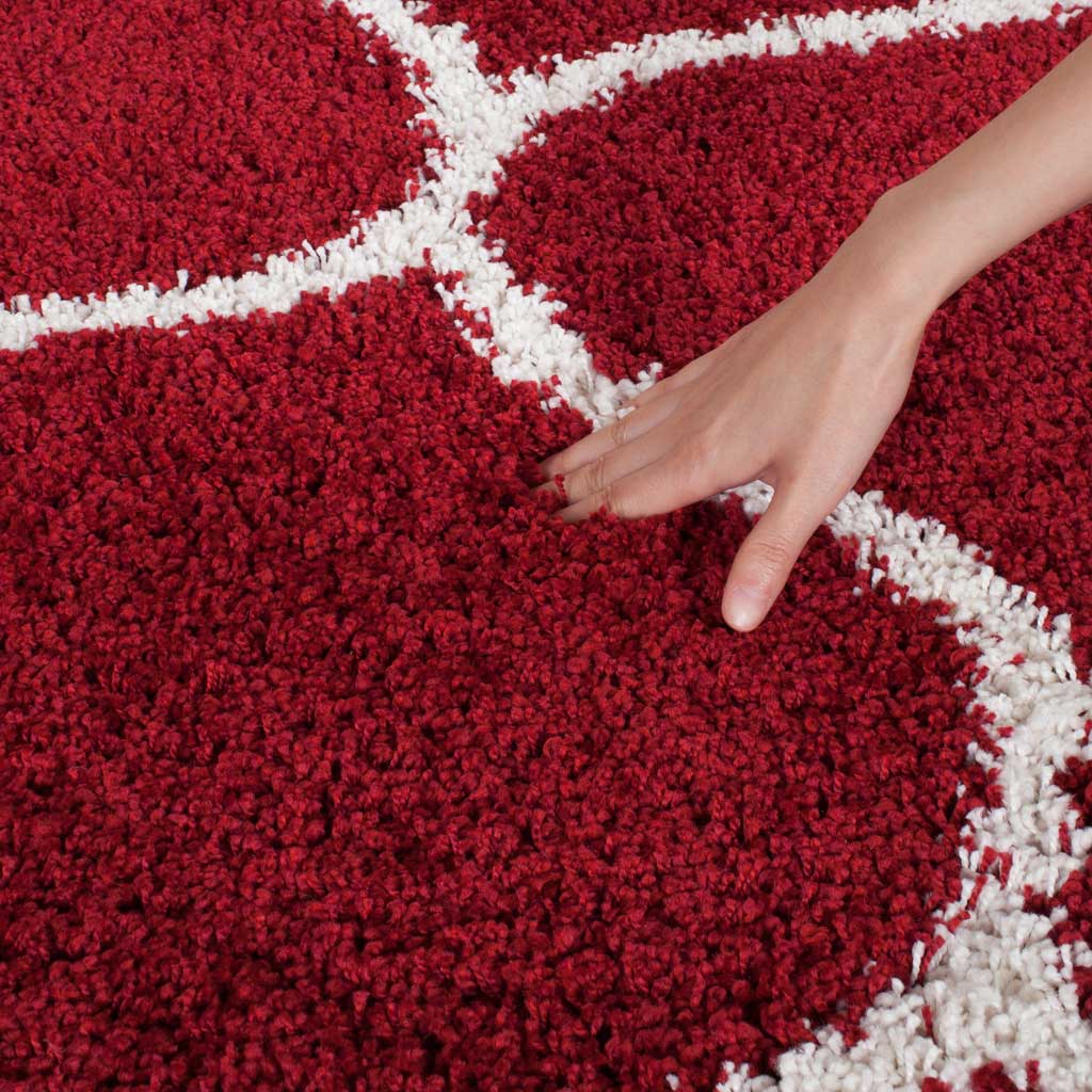 A hand rests in the thick red pile beside an ivory line