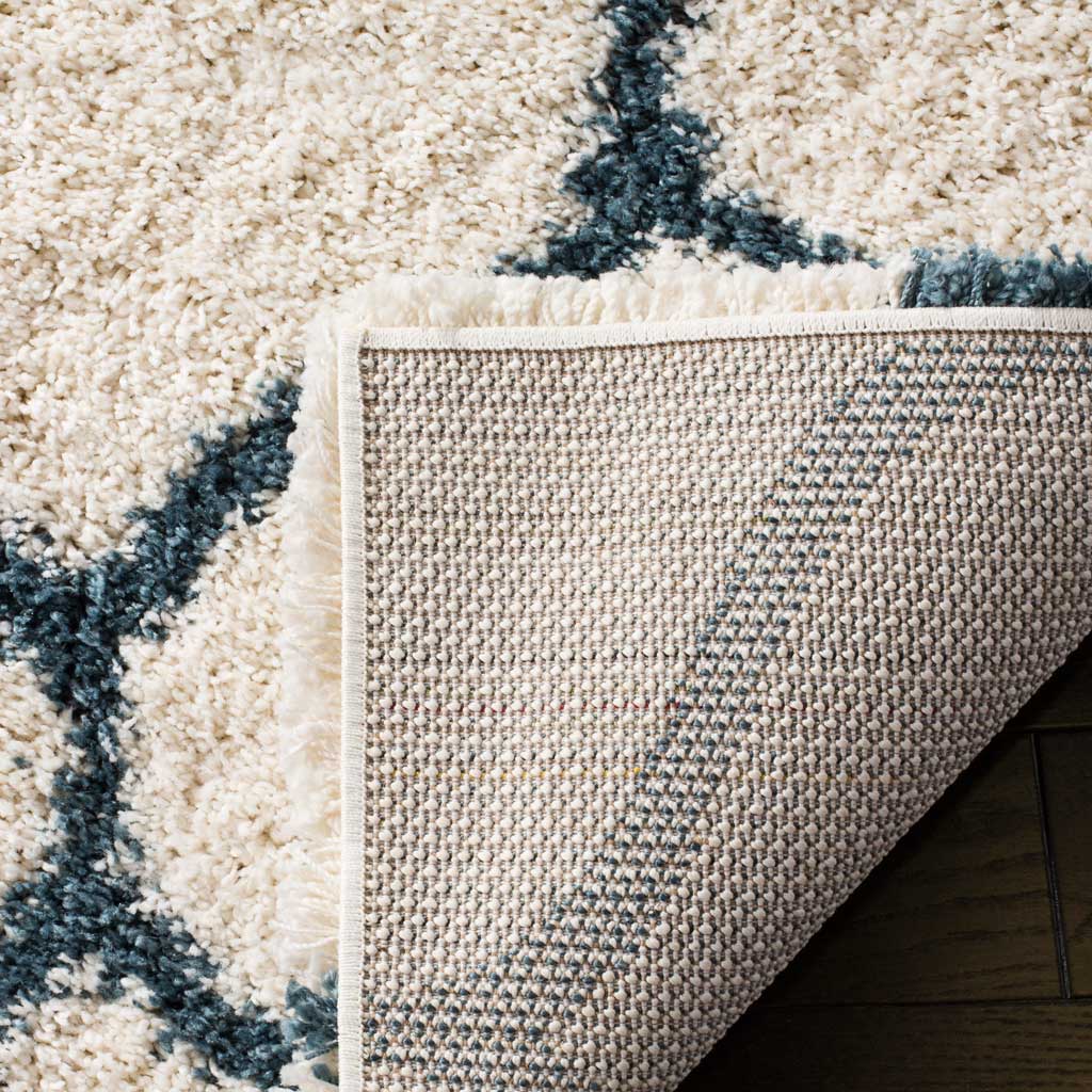 Woven backing and bound edge support the ivory and blue shag