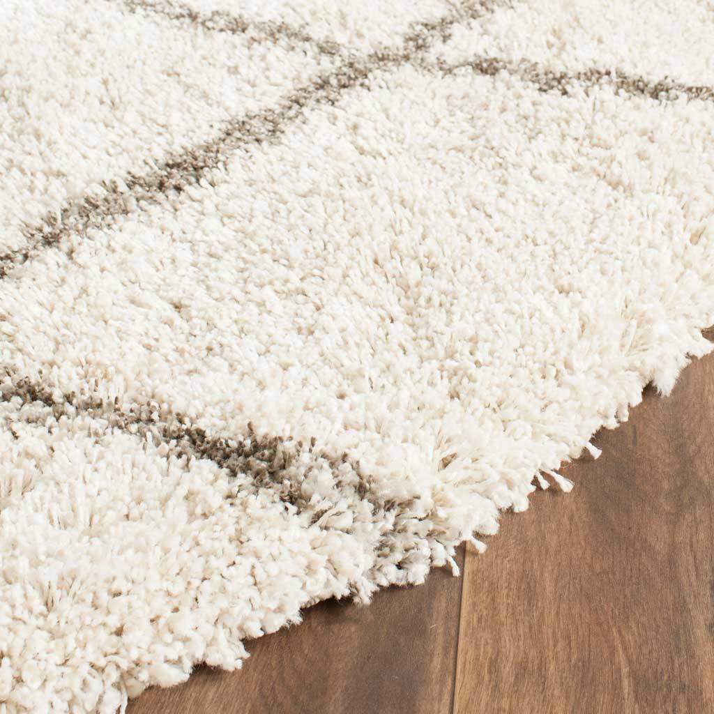 Ivory shag fibers and fine gray lattice lines add depth to the cushioned rug edge