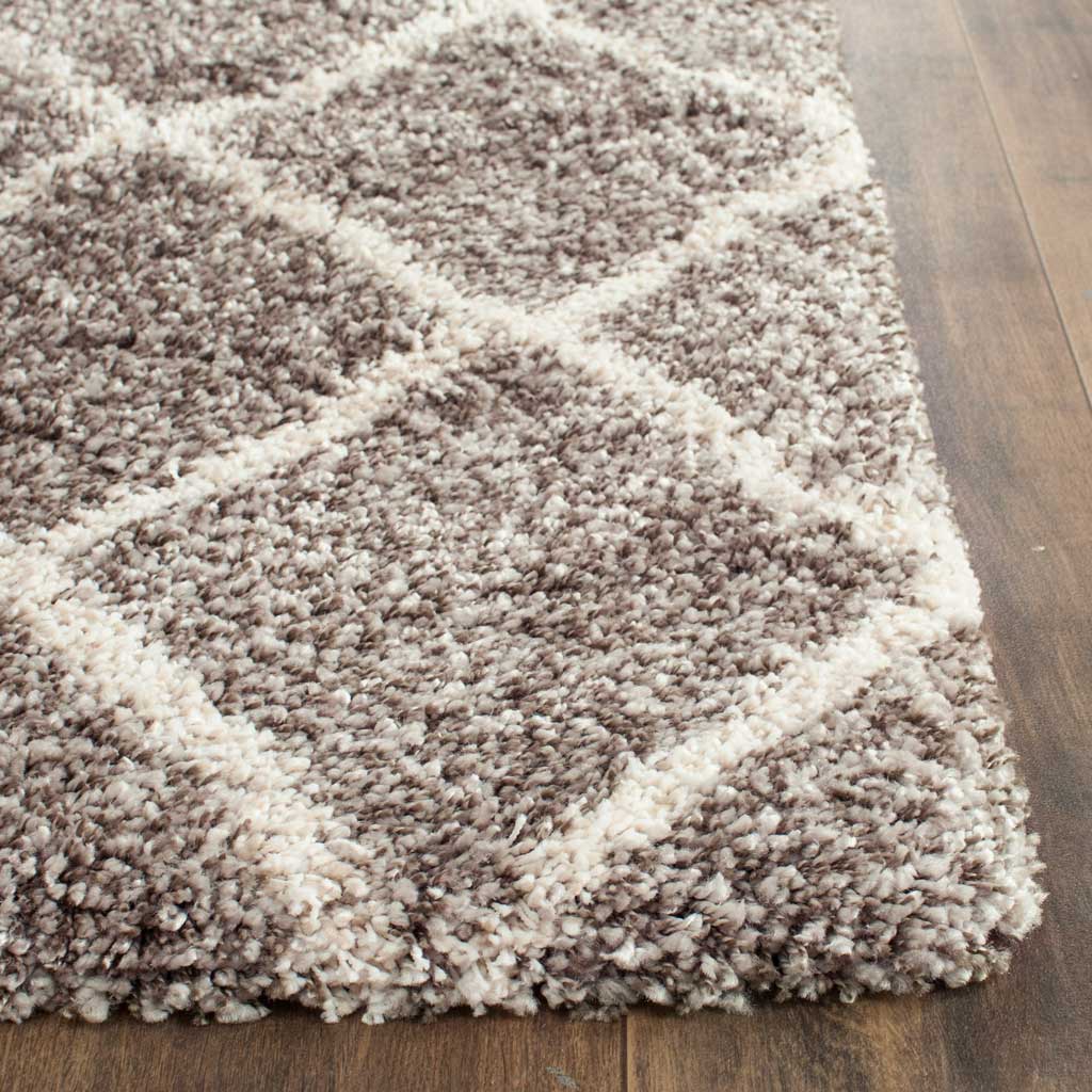 Gray and ivory shag fibers gather along a thick, plush rug corner.