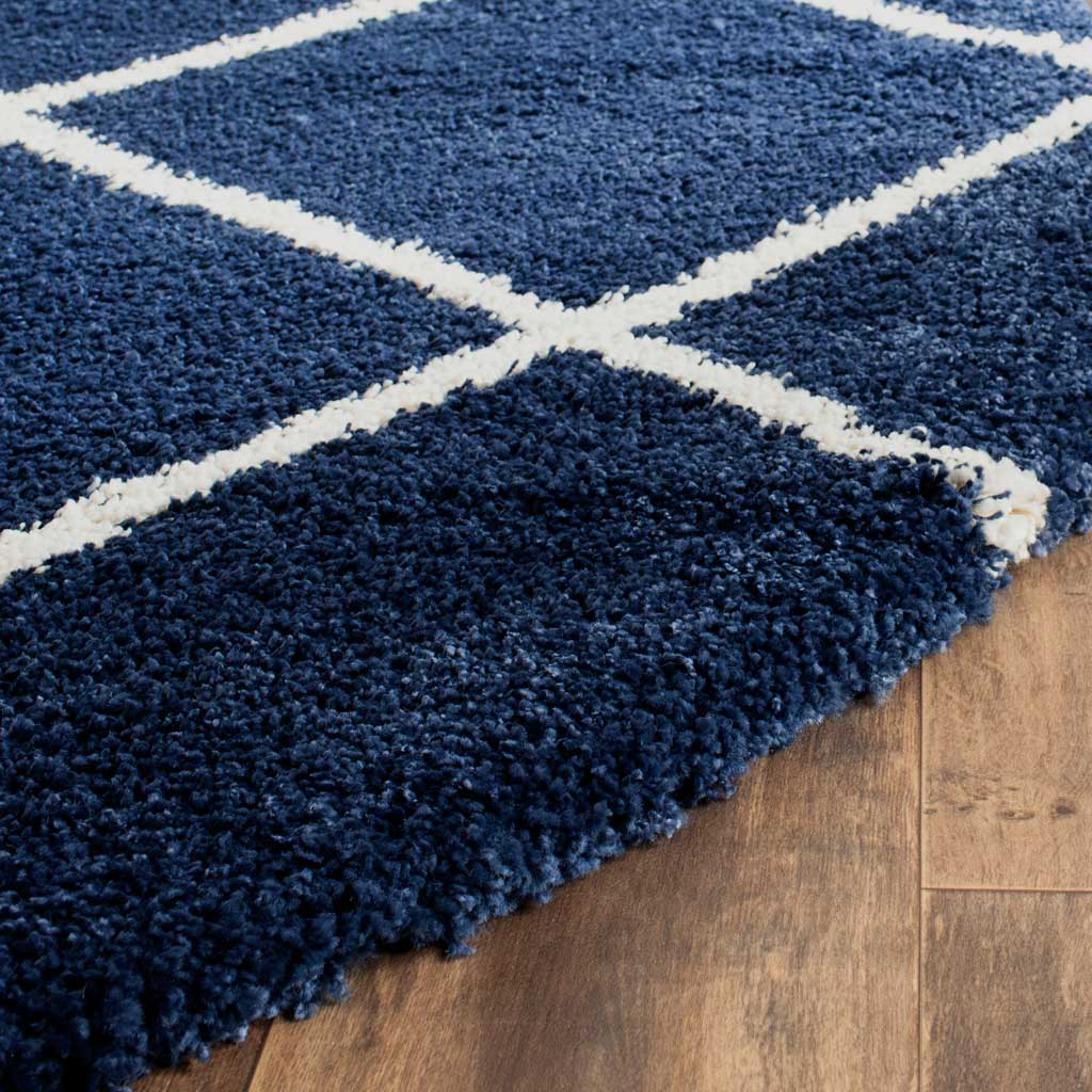 Velvety navy shag and crisp ivory lines meet at a thick, soft rug edge