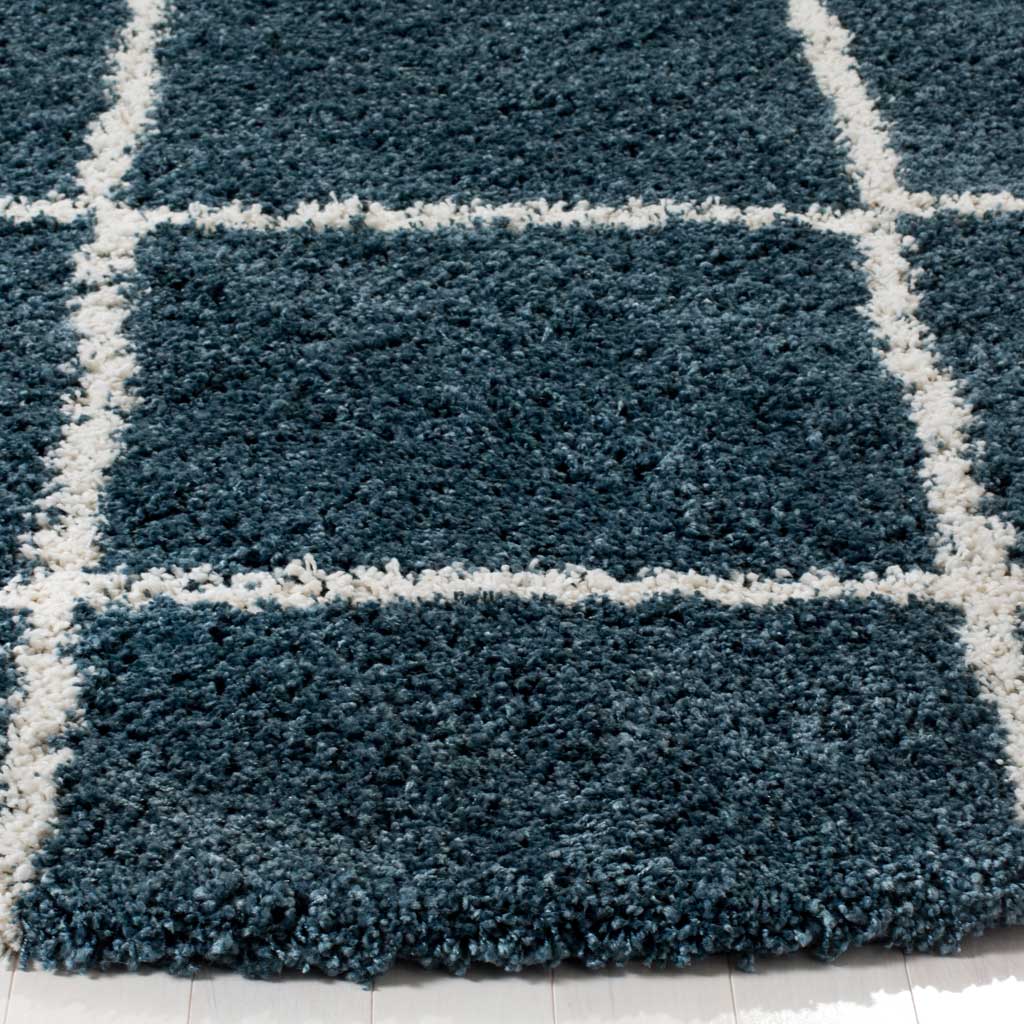 Blue shag fibers and raised ivory lines add contrast at the rug's soft edge
