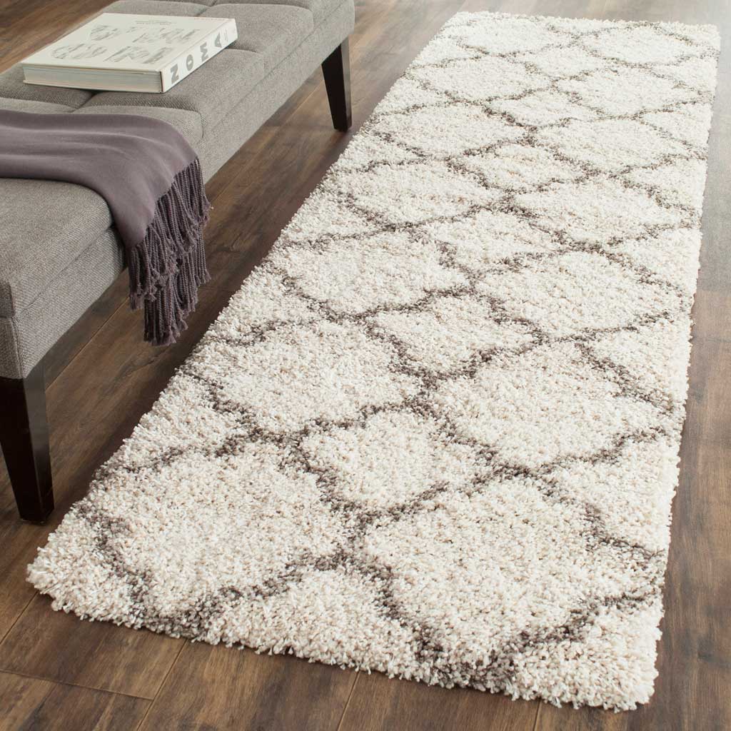 Gray curved trellis motifs bring gentle contrast to the plush ivory surface.