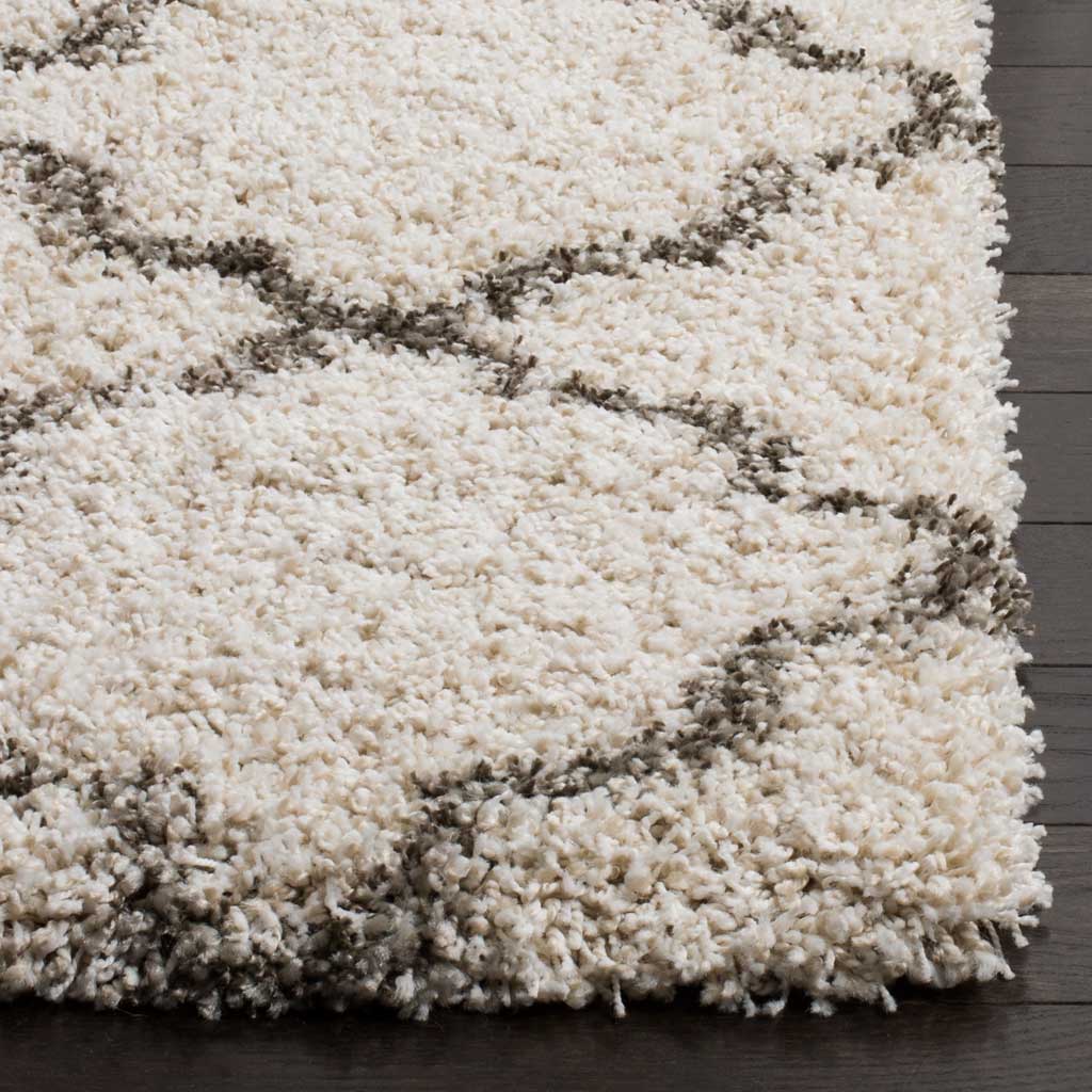 Fluffy ivory fibers and gray quatrefoil lines finish in a plush edge