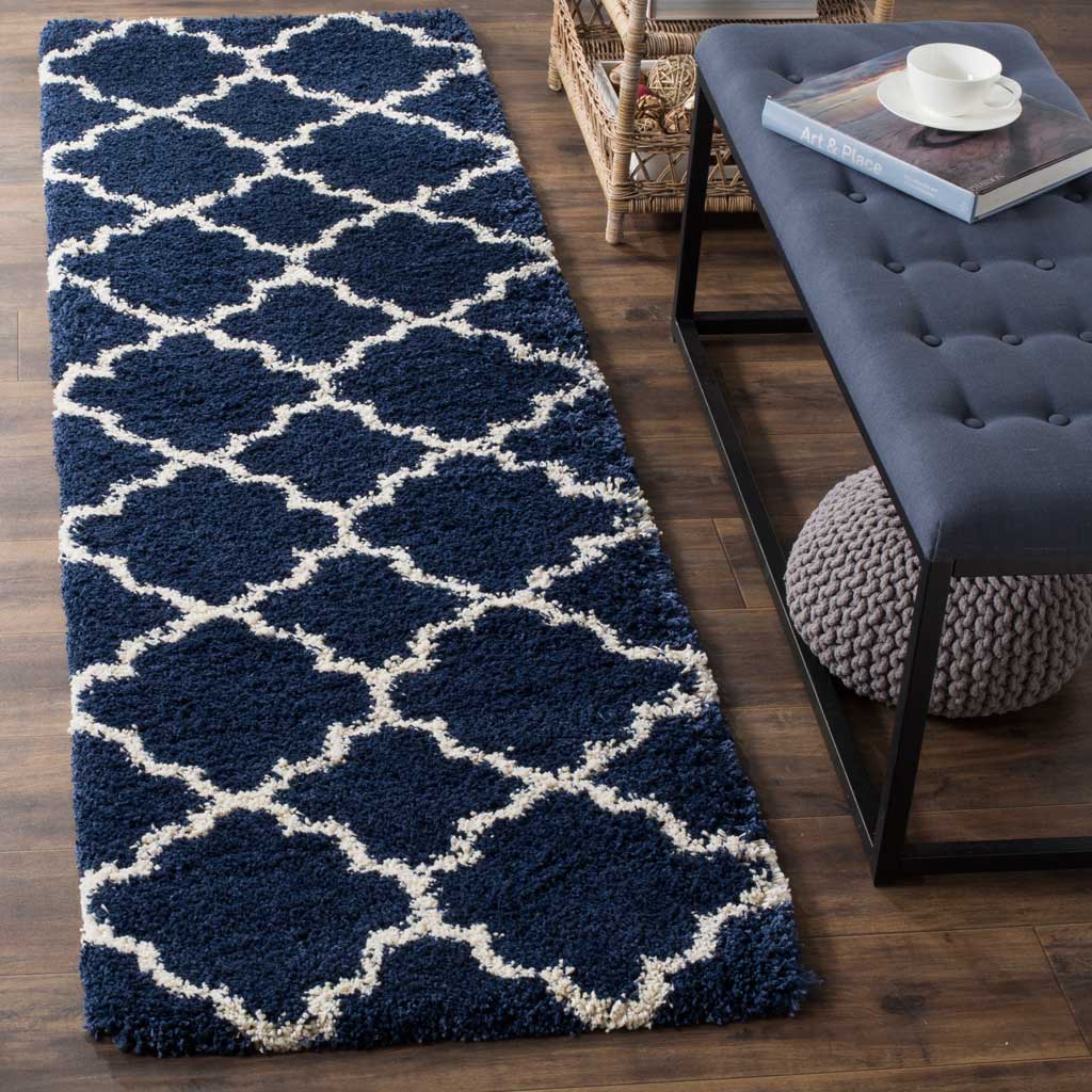 Bright ivory interlocking motifs pop against deep navy shag for striking floor style.