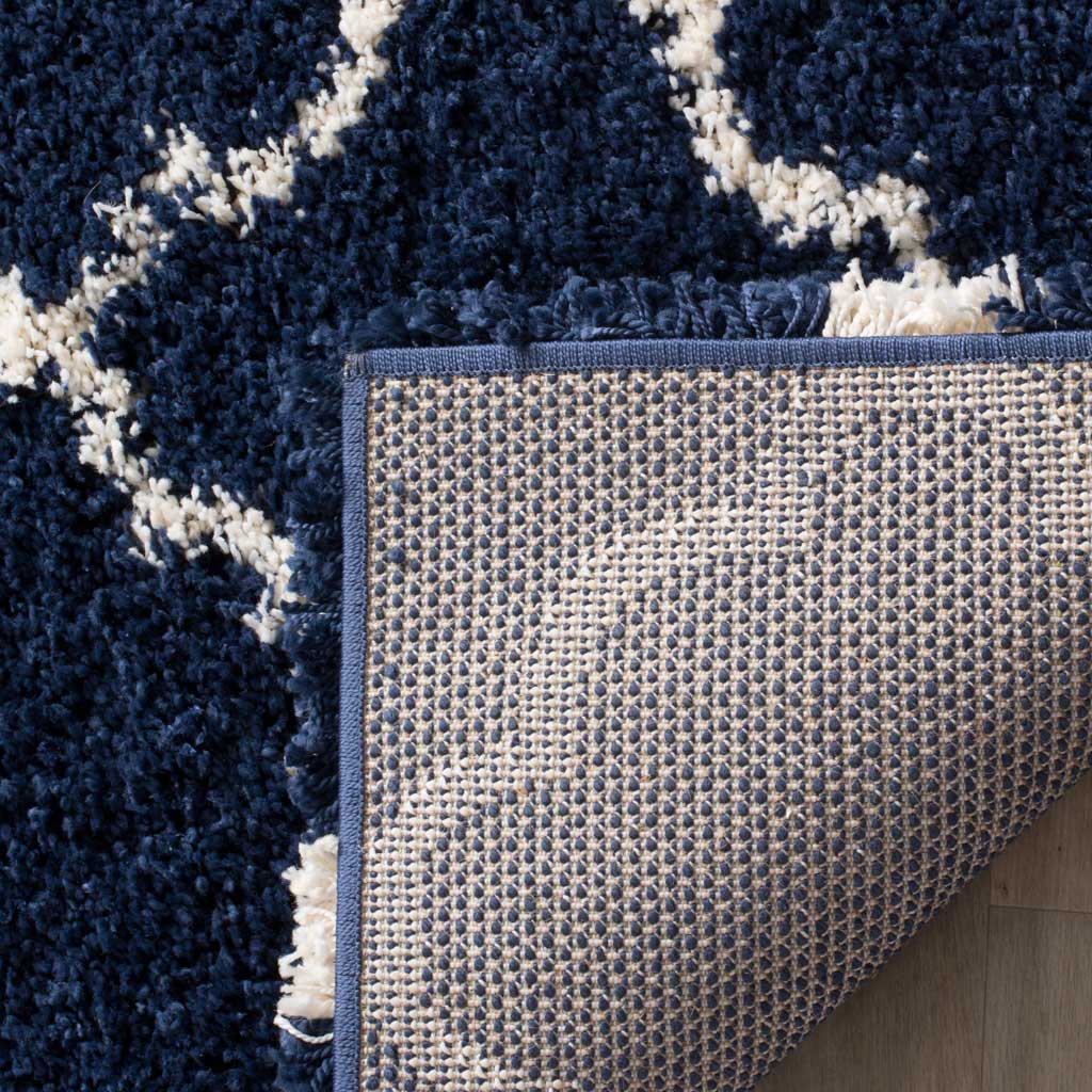 Woven backing and bound navy edge support the patterned rug