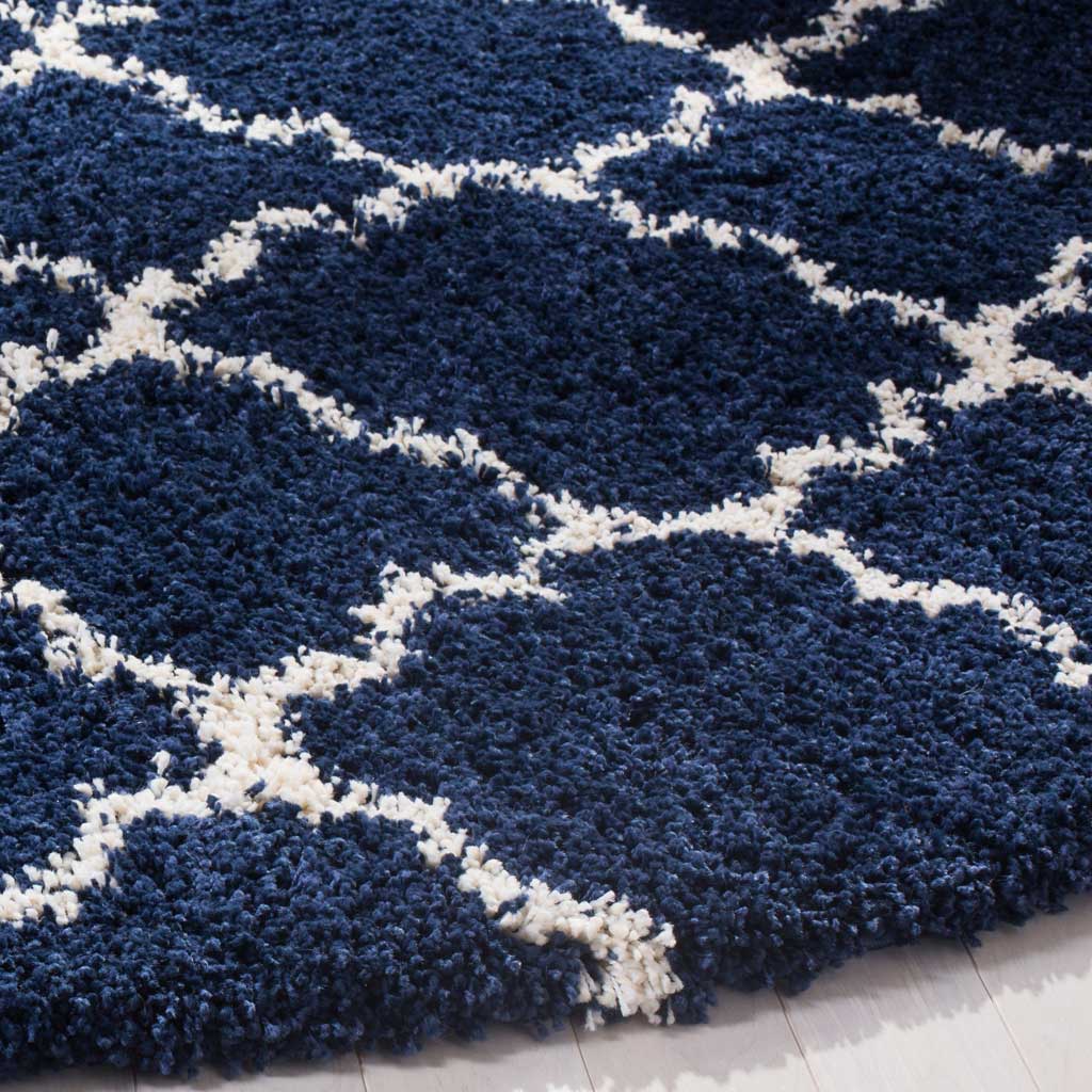 Dense navy shag contrasts with fine ivory quatrefoil lines at the rug's edge