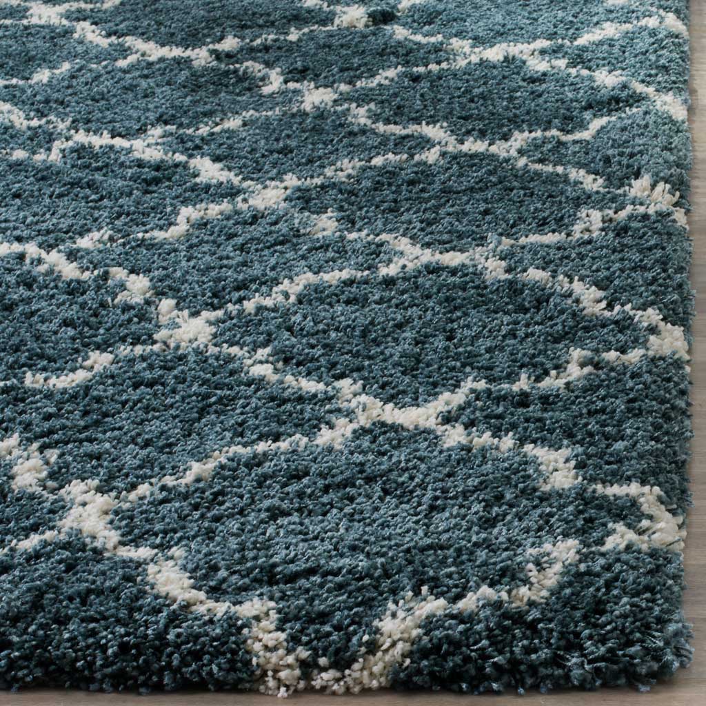 Thick blue pile meets ivory quatrefoil lines at a finished edge