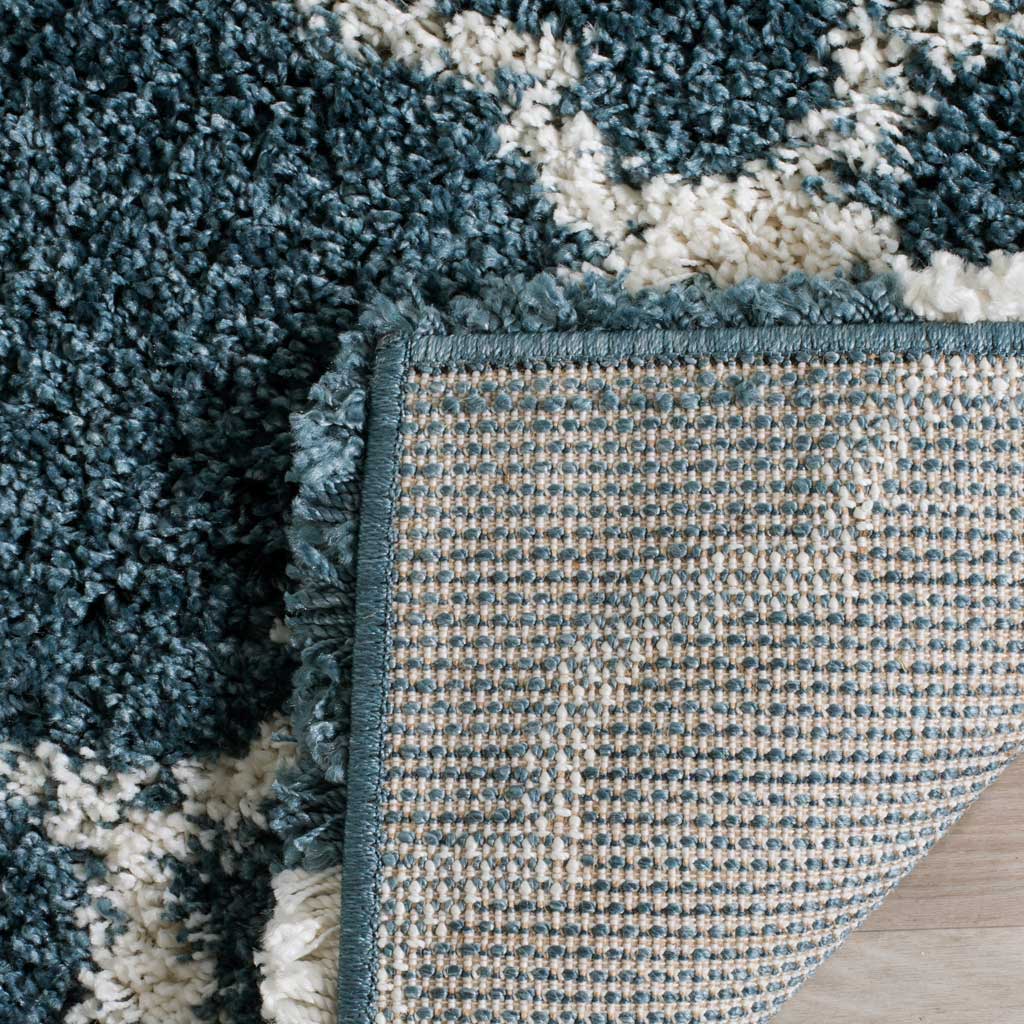 Woven underside and blue binding support the plush patterned rug