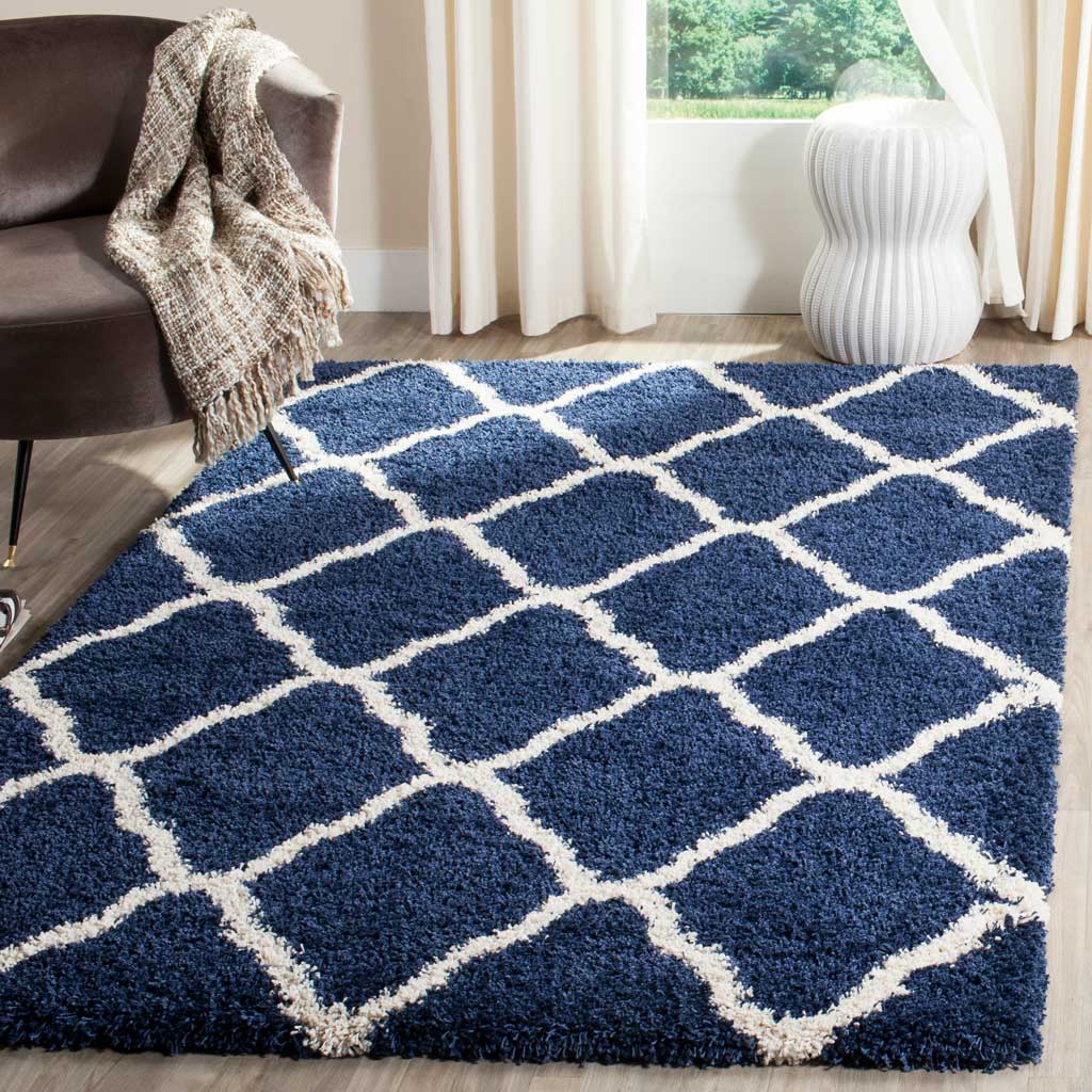 Navy curved diamond rug adds depth beside dark upholstered seating