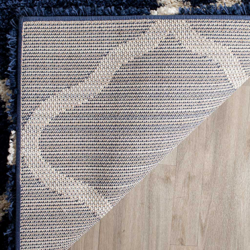 Woven underside and navy bound edge support the shag rug
