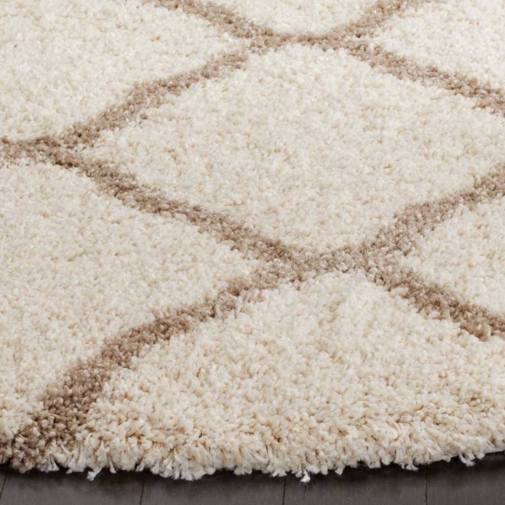 Plush ivory fibers and beige lattice lines create a soft, inviting rug edge