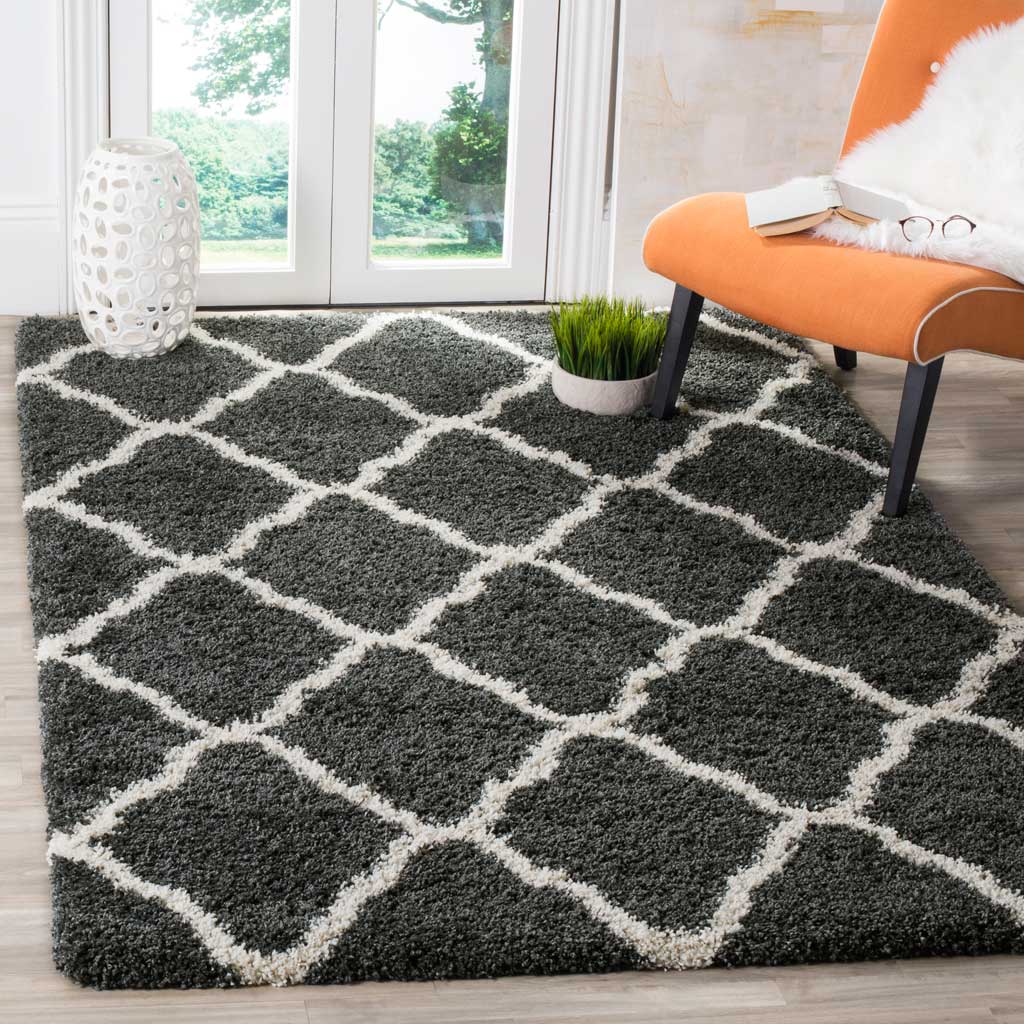 Dark gray diamond rug adds cozy contrast beside orange seating