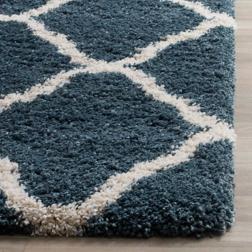 Thick slate blue fibers frame an ivory line at the rug's edge