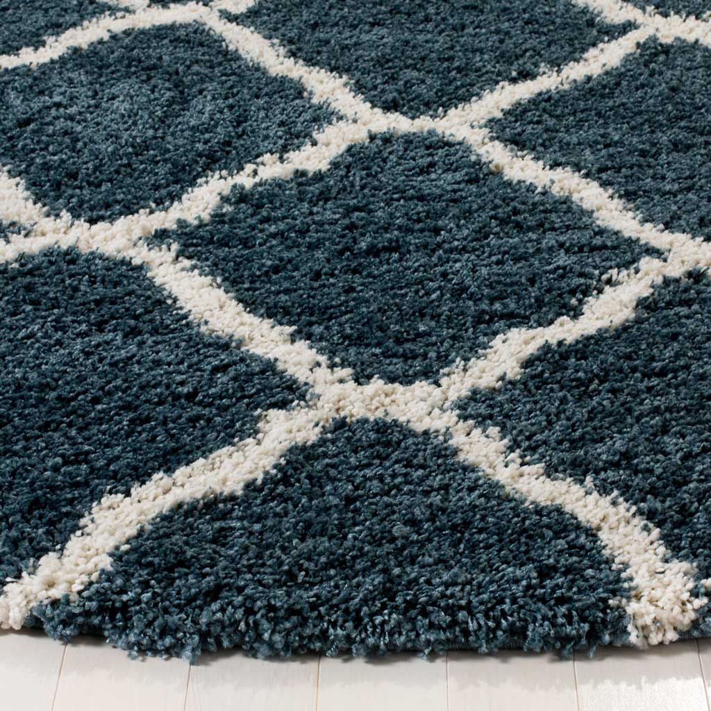 Lush slate blue shag contrasts with ivory trellis lines at the rug's soft edge