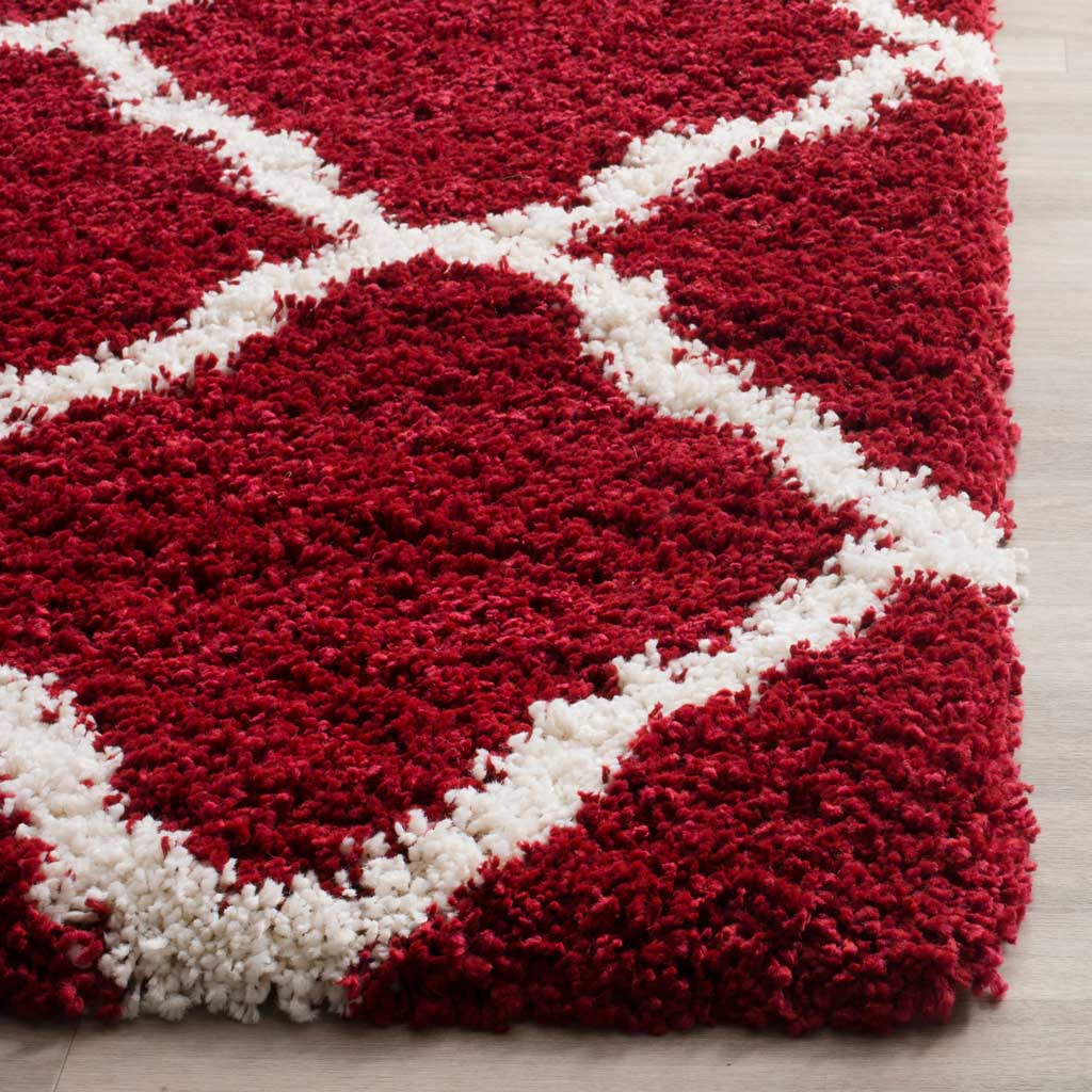 Thick red pile frames ivory diagonals at a plush finished edge