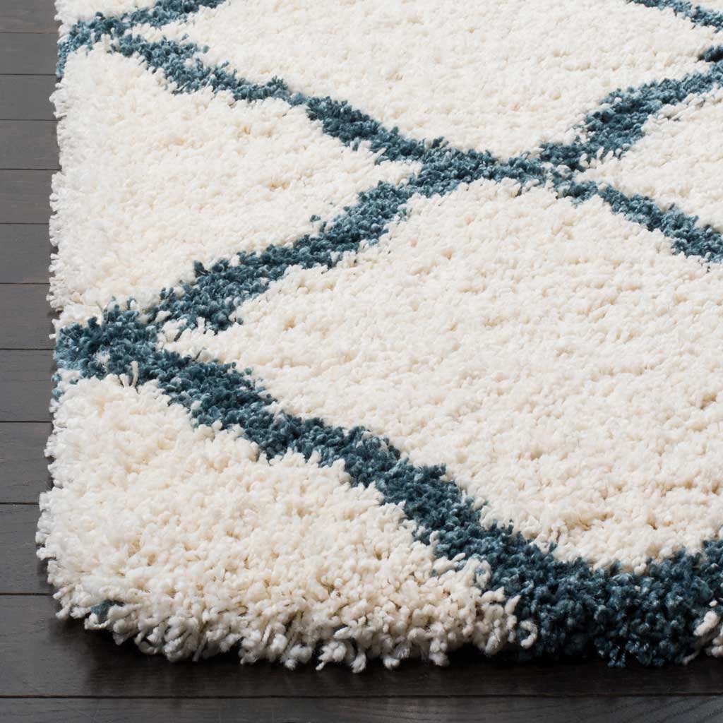 Plush ivory fibers frame steel blue diagonals at the rug's edge