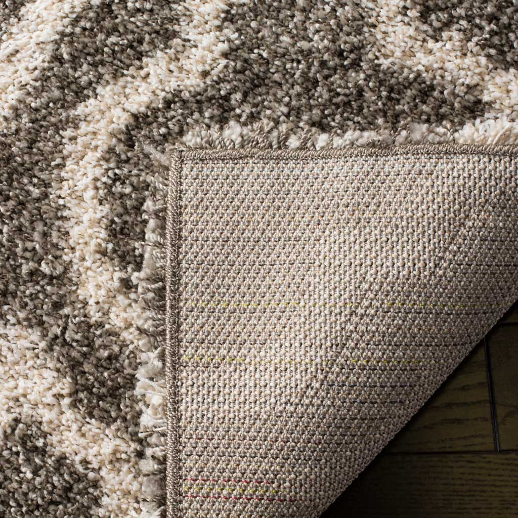 Woven backing and a bound edge support the patterned gray shag