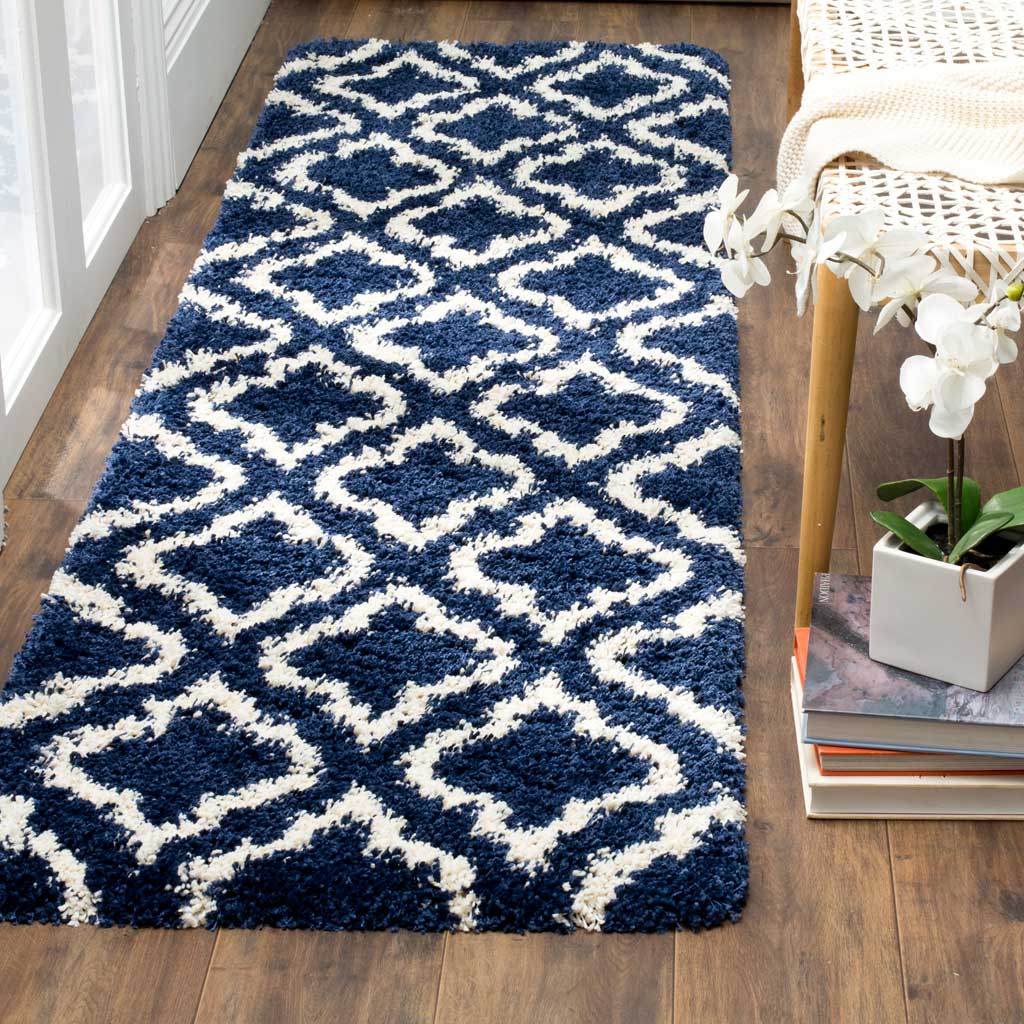 Creamy ivory curving motifs wind across the deep navy shag runner.