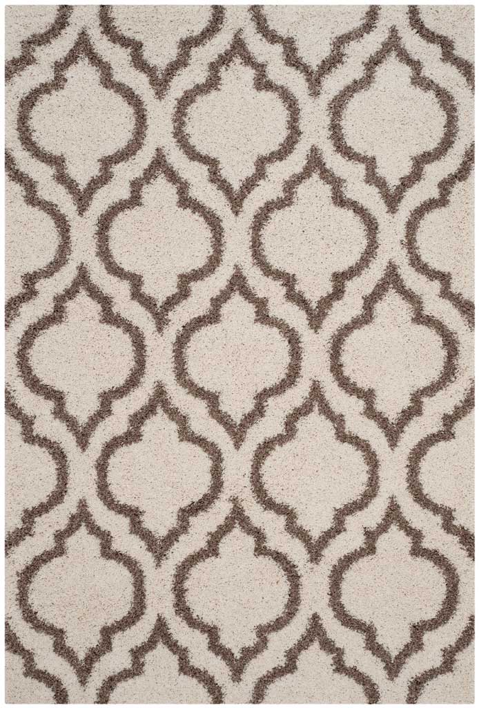 Beige outlines form graceful repeating motifs across ivory shag