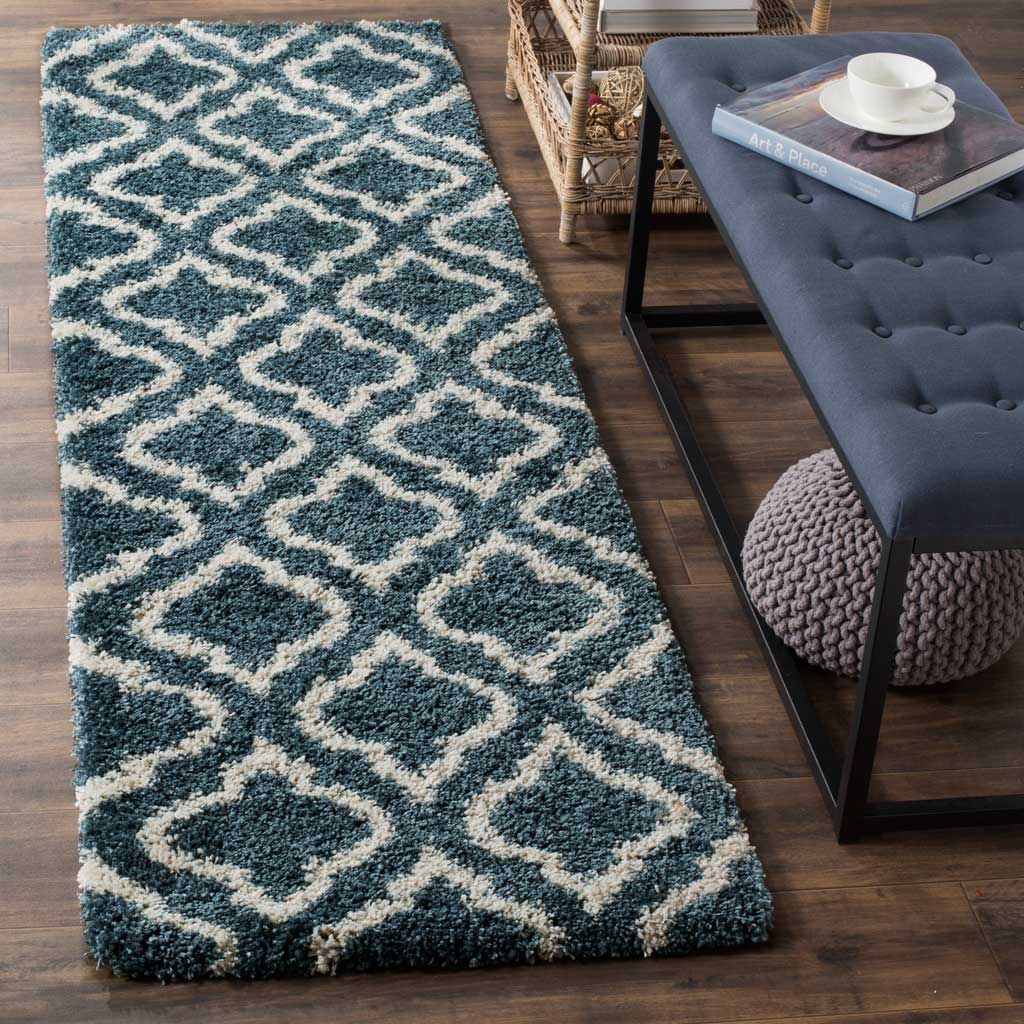 Ivory interlacing curves brighten the rich slate blue pile of this runner.