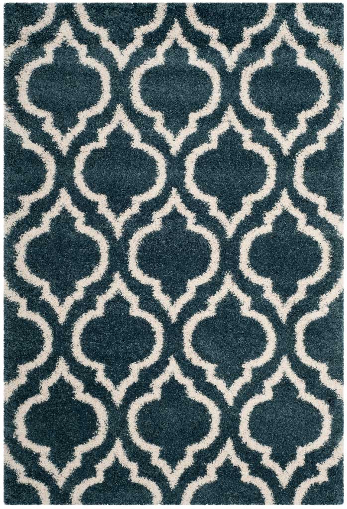 Plush slate blue pile framed by a repeating ivory ornamental motif