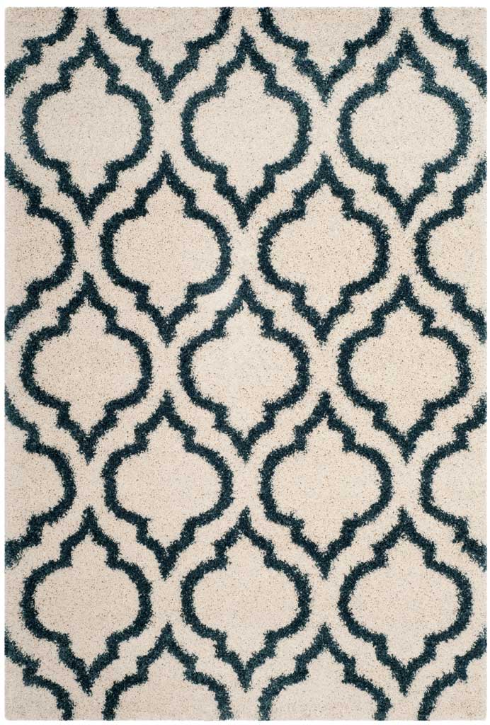 Blue arabesque outlines flow across the rug's deep ivory pile