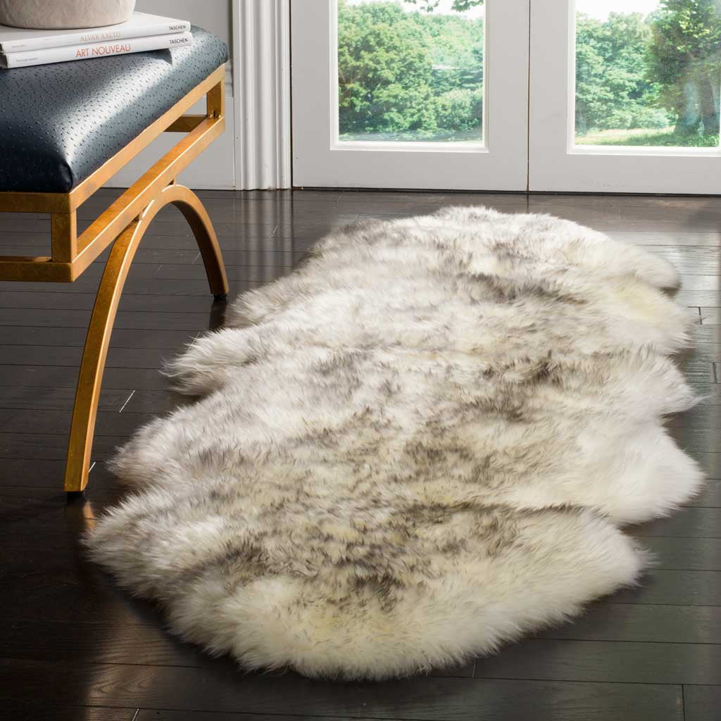 Fluffy ivory and smoke gray sheepskin lends a soft contrast to dark floors