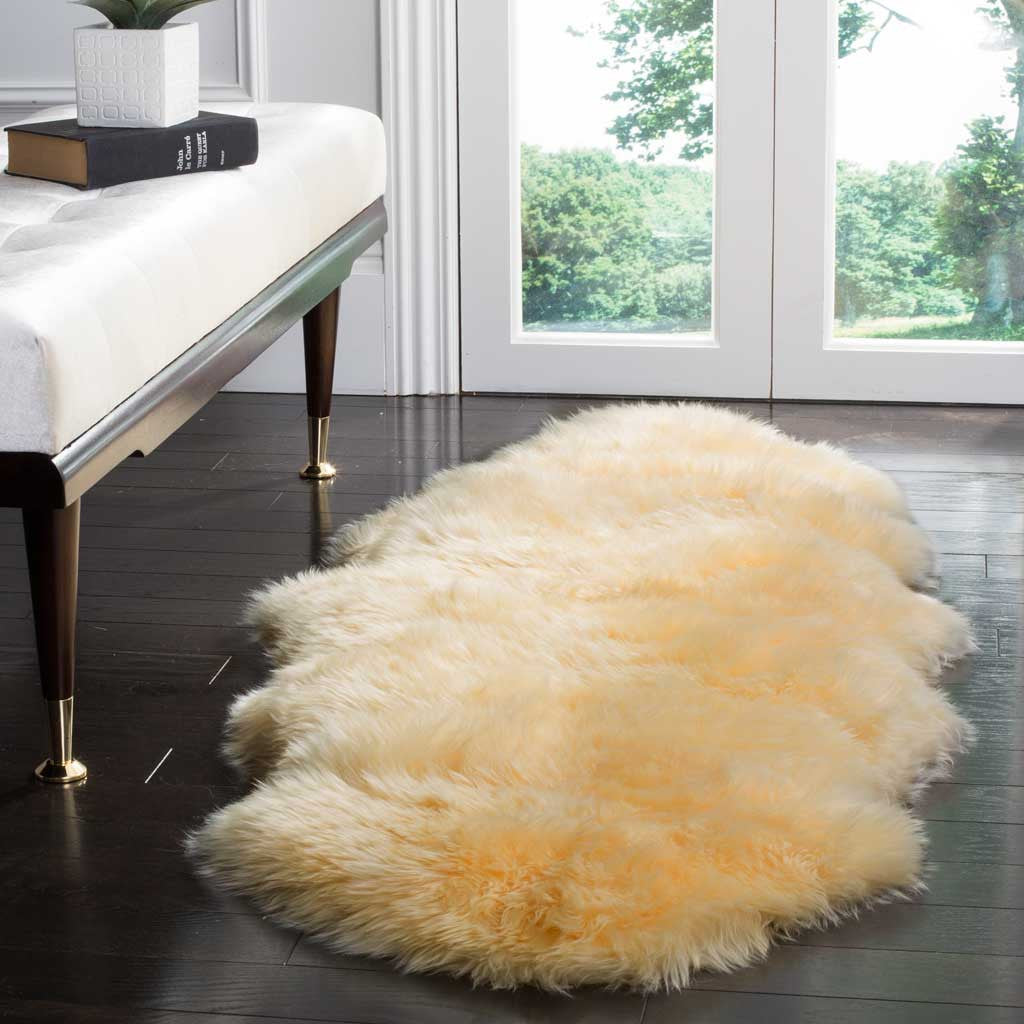 Warm champagne sheepskin adds a fluffy accent to dark wood flooring