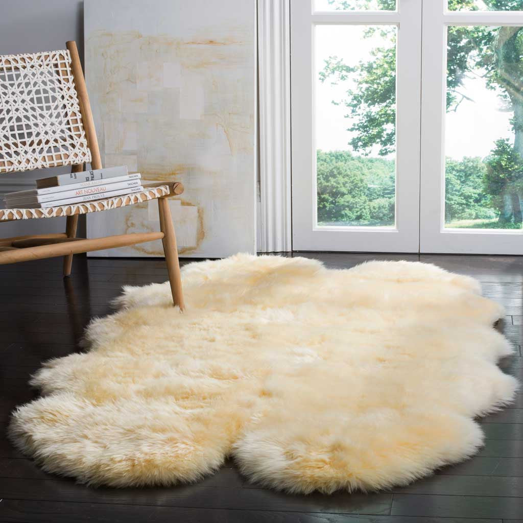 Creamy sheepskin softens the dark floor beneath a woven chair.