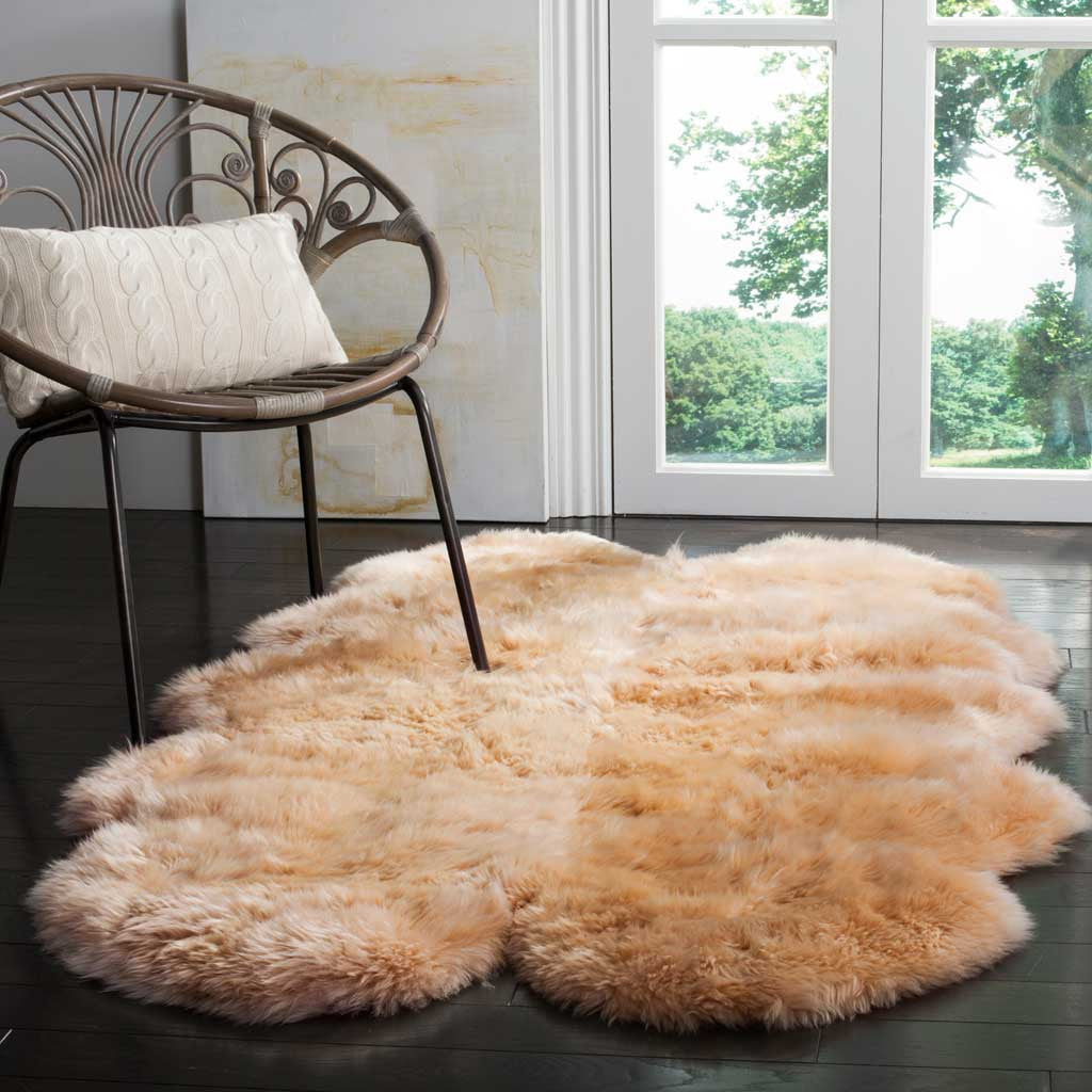 A plush beige sheepskin rug warms the dark floor beside a curved accent chair.