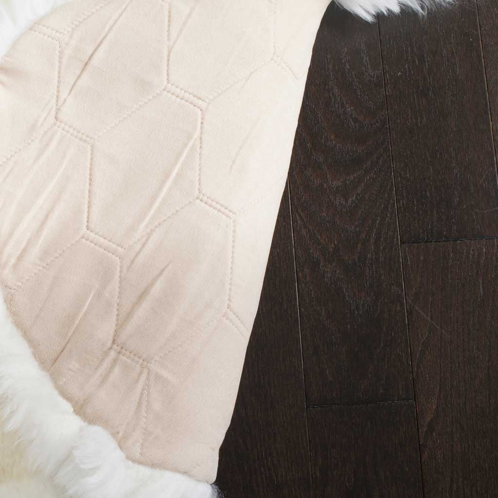 Stitched panels on the pale backing add structure beneath the white sheepskin pile.