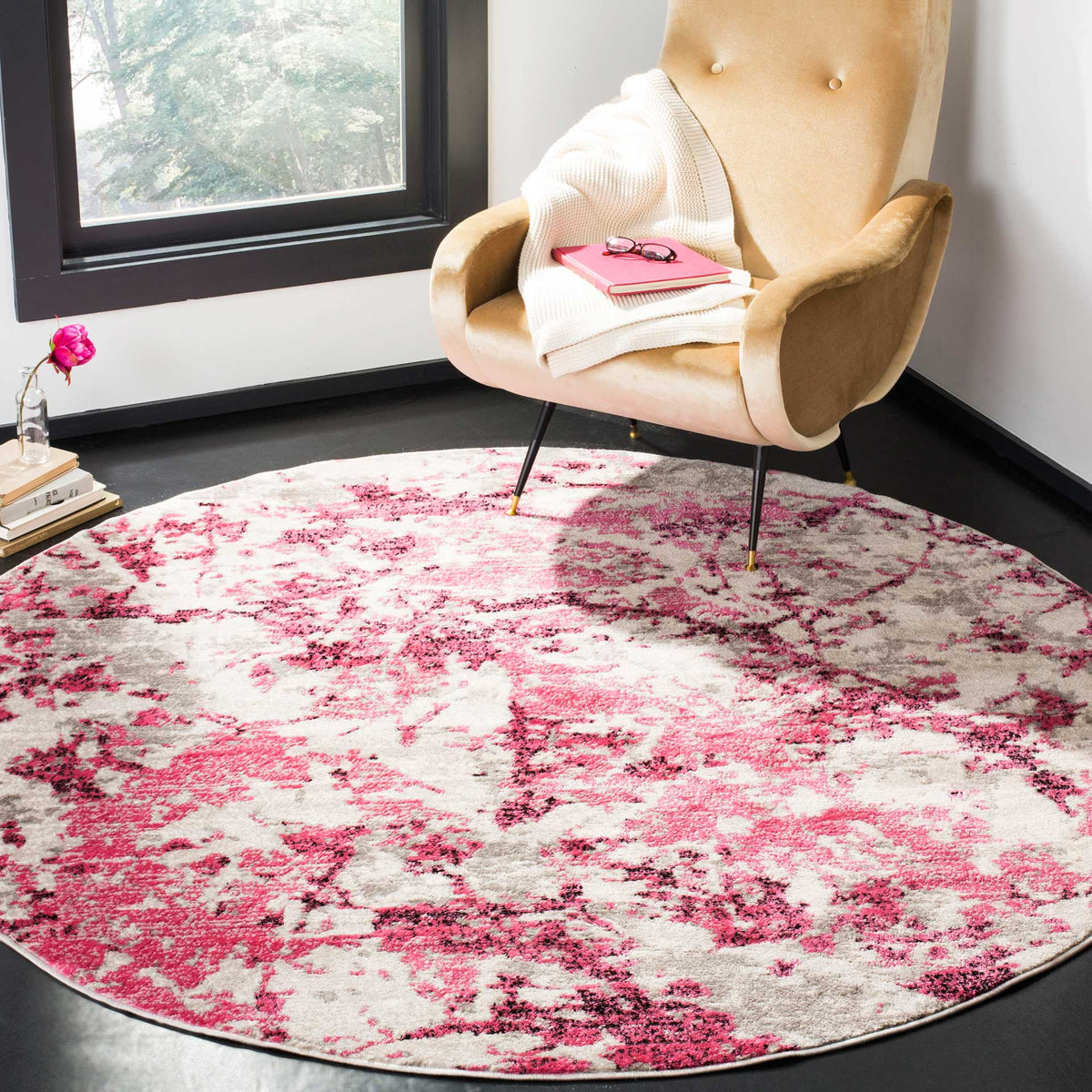 A pink and ivory abstract rug brings bright color beneath a tufted accent chair.