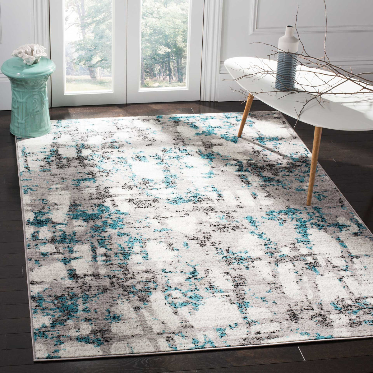 Turquoise blue and gray accents bring lively contrast to an ivory rug beneath modern furnishings