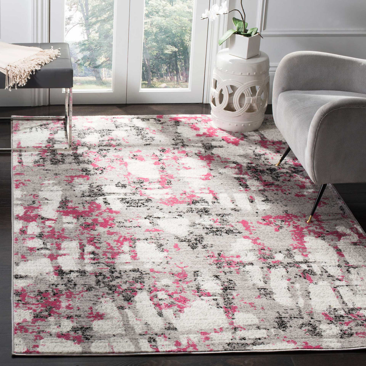 Gray and bright pink abstract rug creates a colorful foundation for a modern seating area