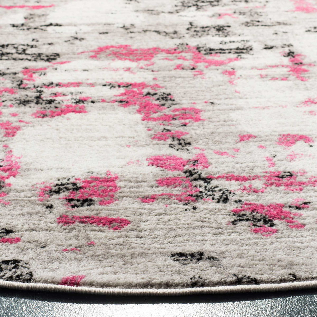 Pink and charcoal markings enliven the textured gray pile and neatly bound curved edge.