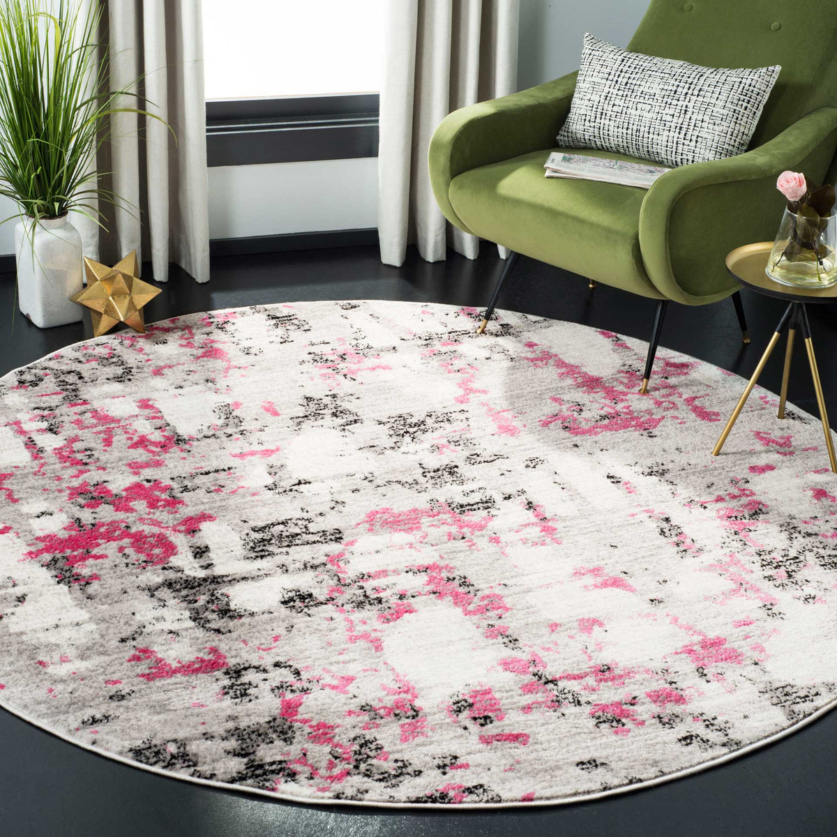 This round rug brings lively pink accents and a distressed gray pattern to a modern seating area.