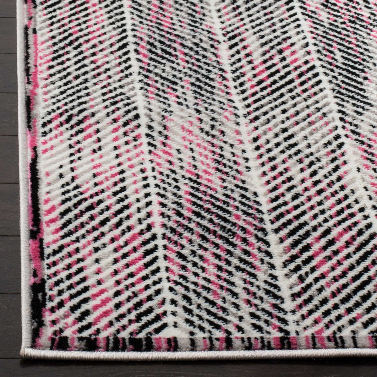 Pink and charcoal chevrons give the softly textured bound rug corner a vibrant touch