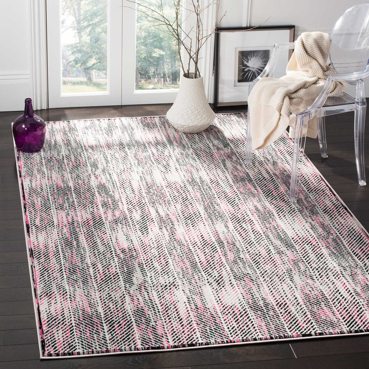 Pink and gray chevrons bring a playful touch beneath a clear accent chair