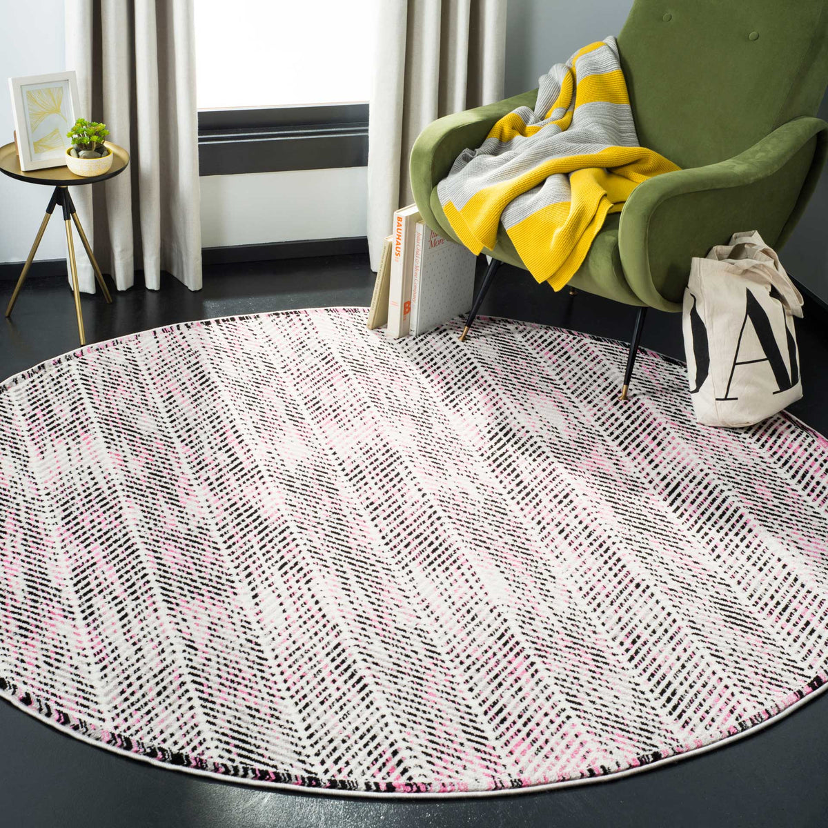 Gray and pink round rug adds playful herringbone pattern beneath a green lounge chair