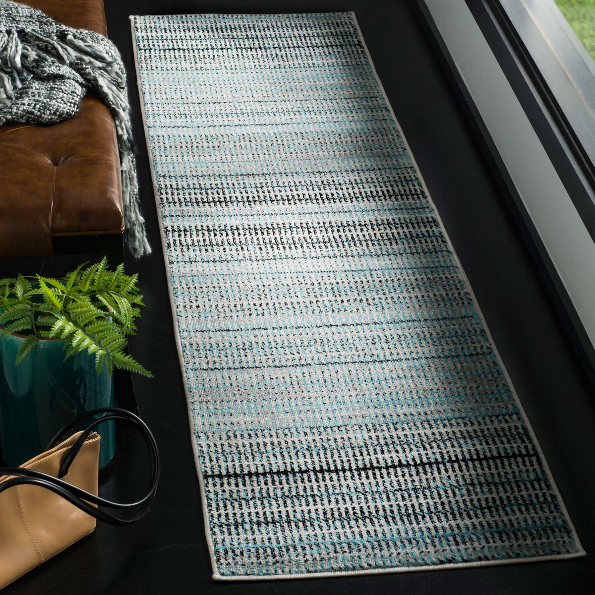 Long blue and gray runner rug brings varied stripes and subtle texture to a modern living space.