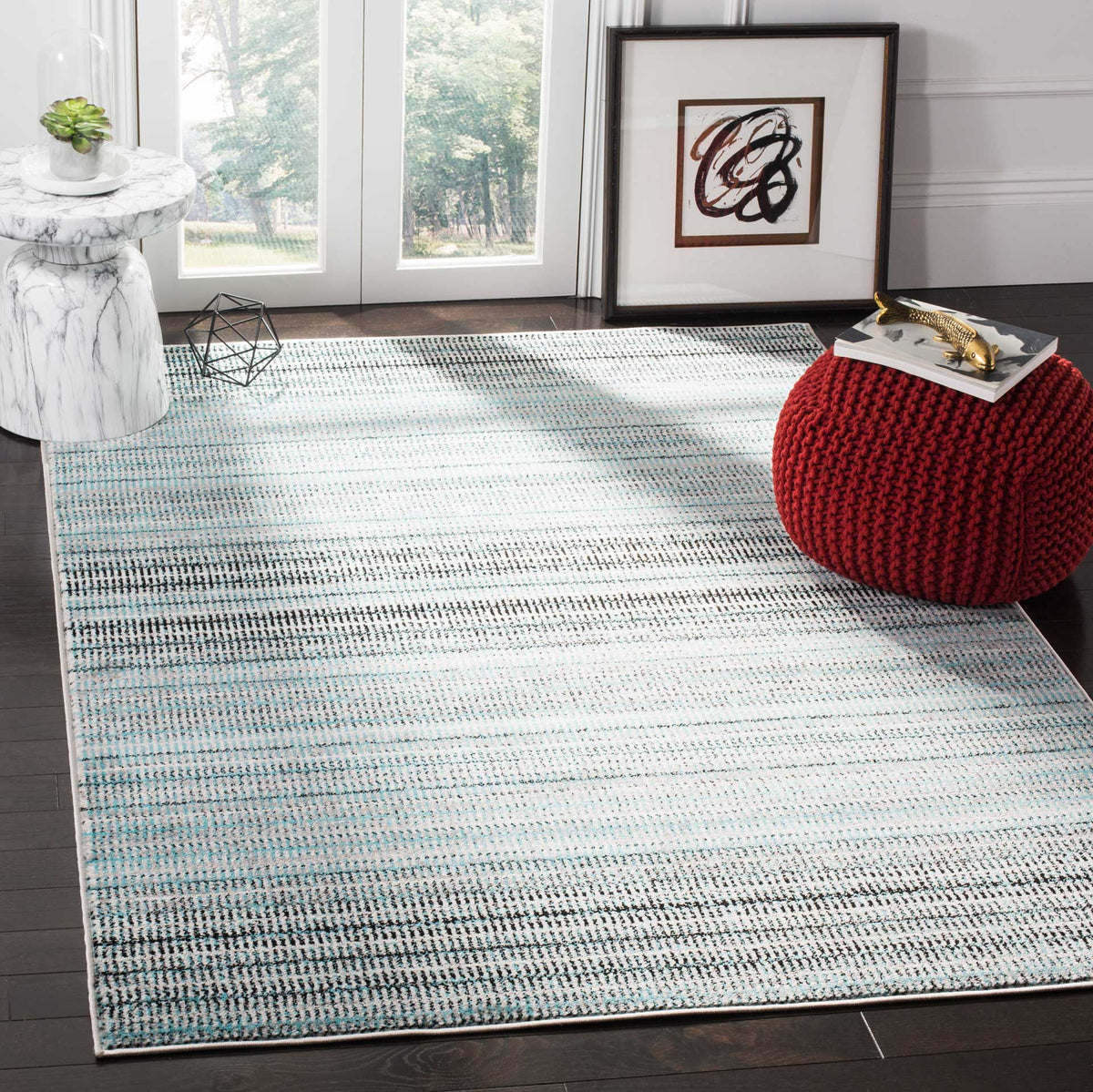 A blue and gray striped rug grounds the space with soft texture and a fresh, contemporary palette.